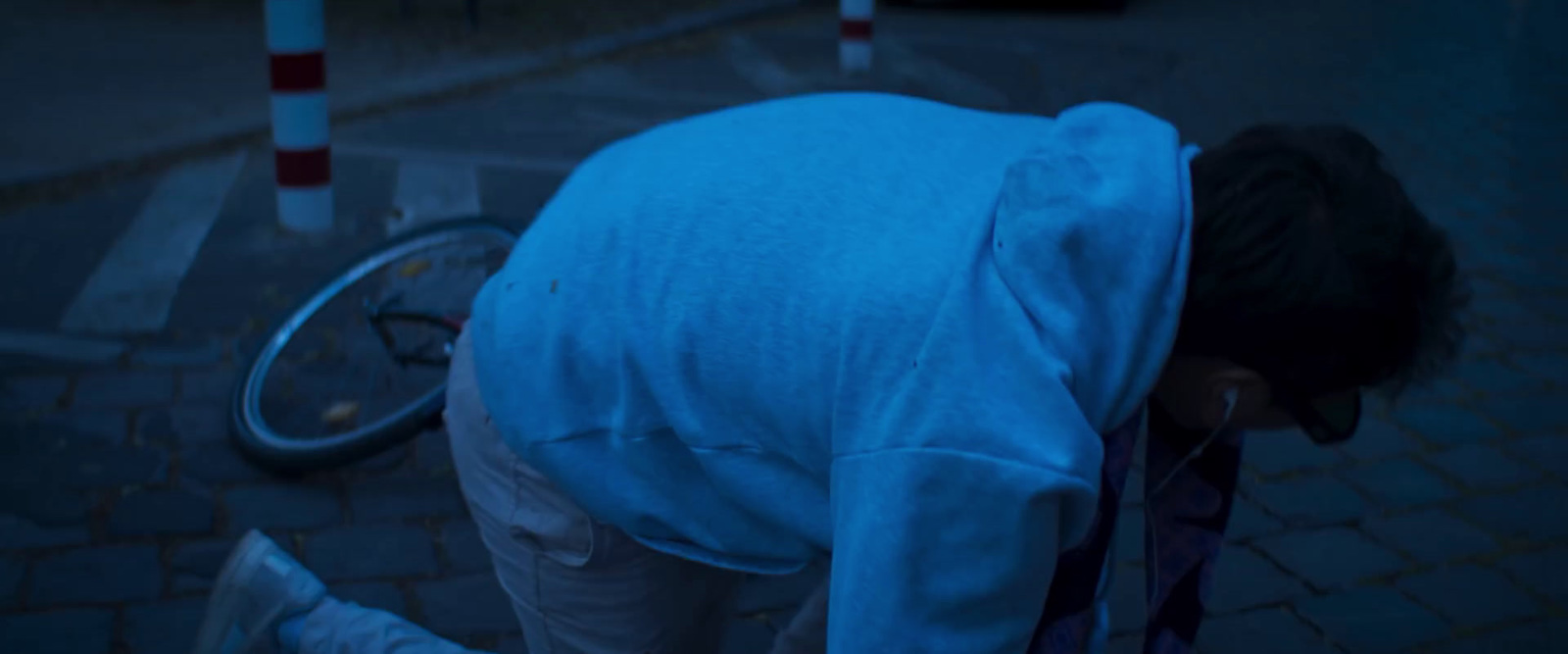 a person bending over on the ground next to a bike