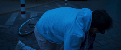 a person bending over on the ground next to a bike