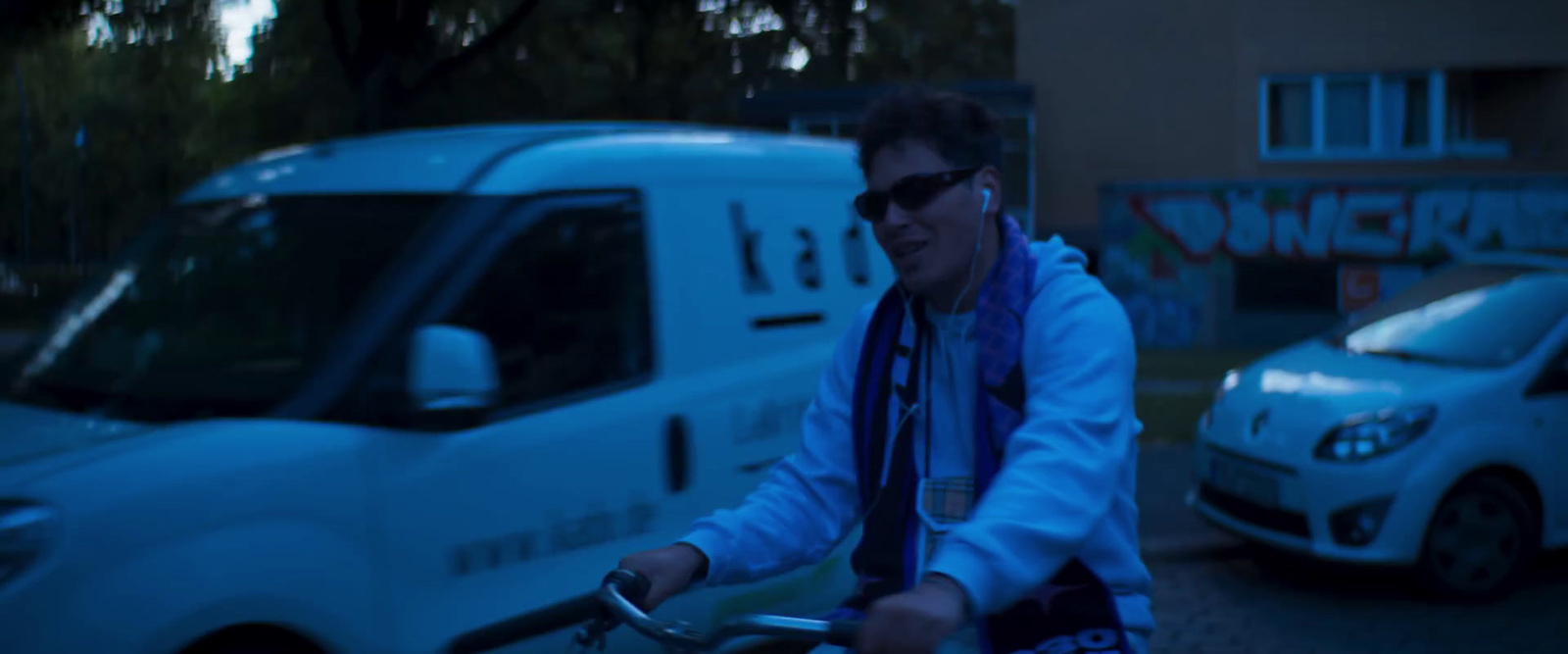 a man riding a bike in front of a van