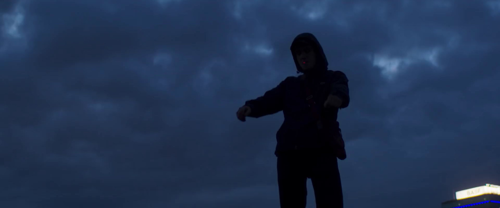 a man standing on top of a roof in the dark