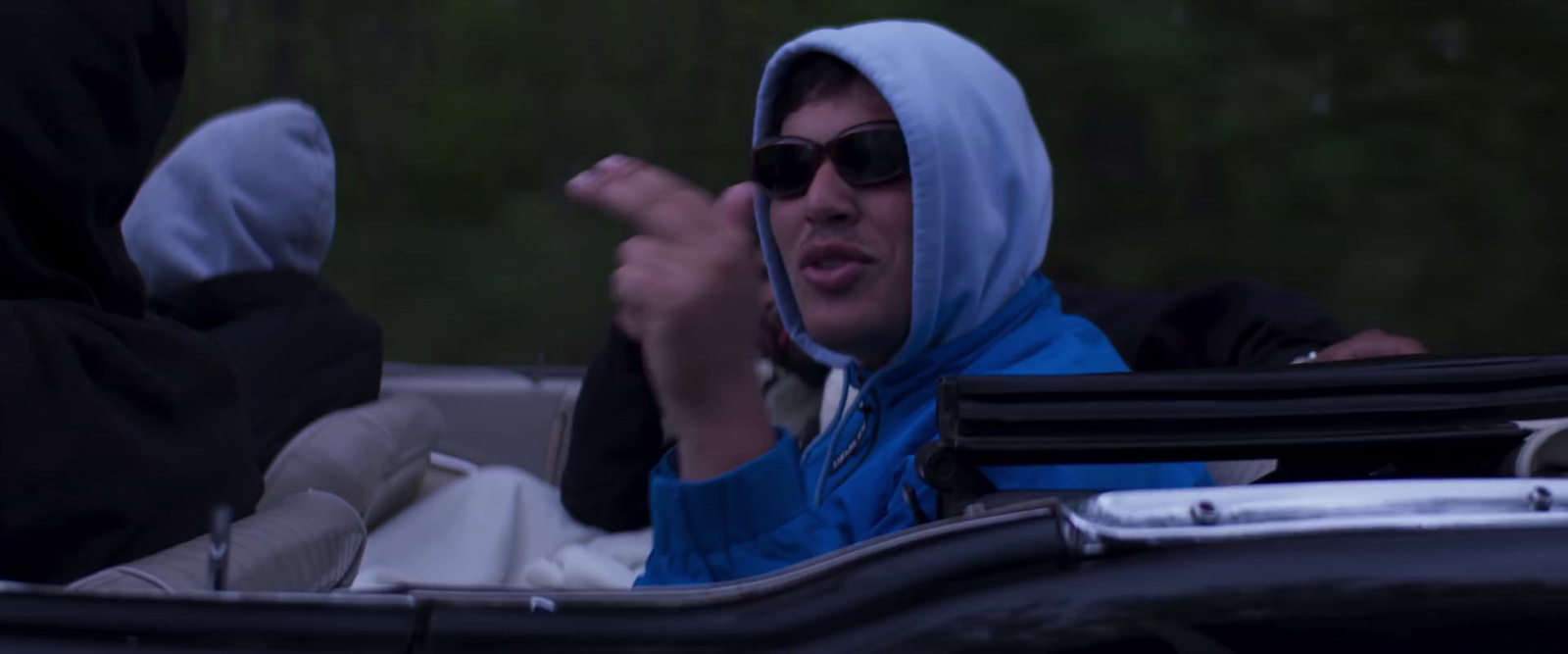 a woman in sunglasses and a blue scarf in a car