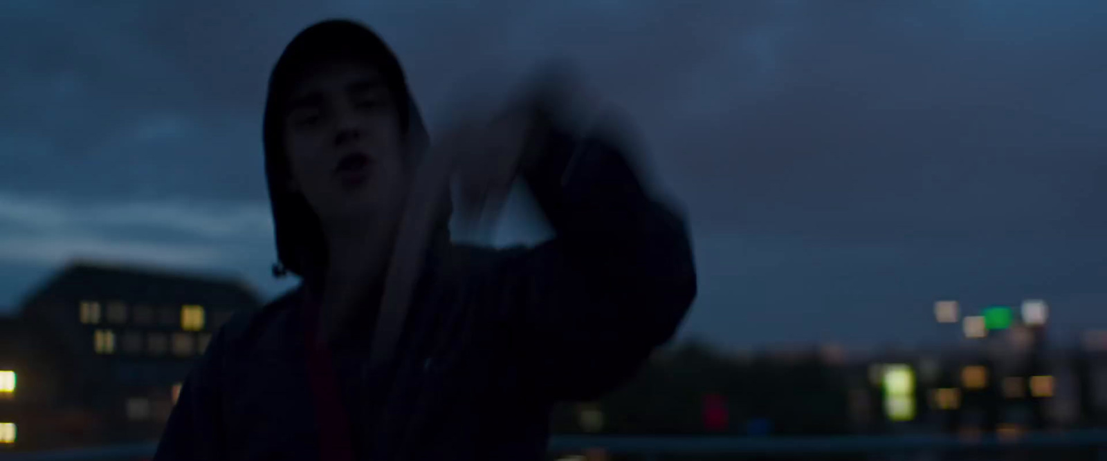 a man holding a baseball bat on a cloudy night