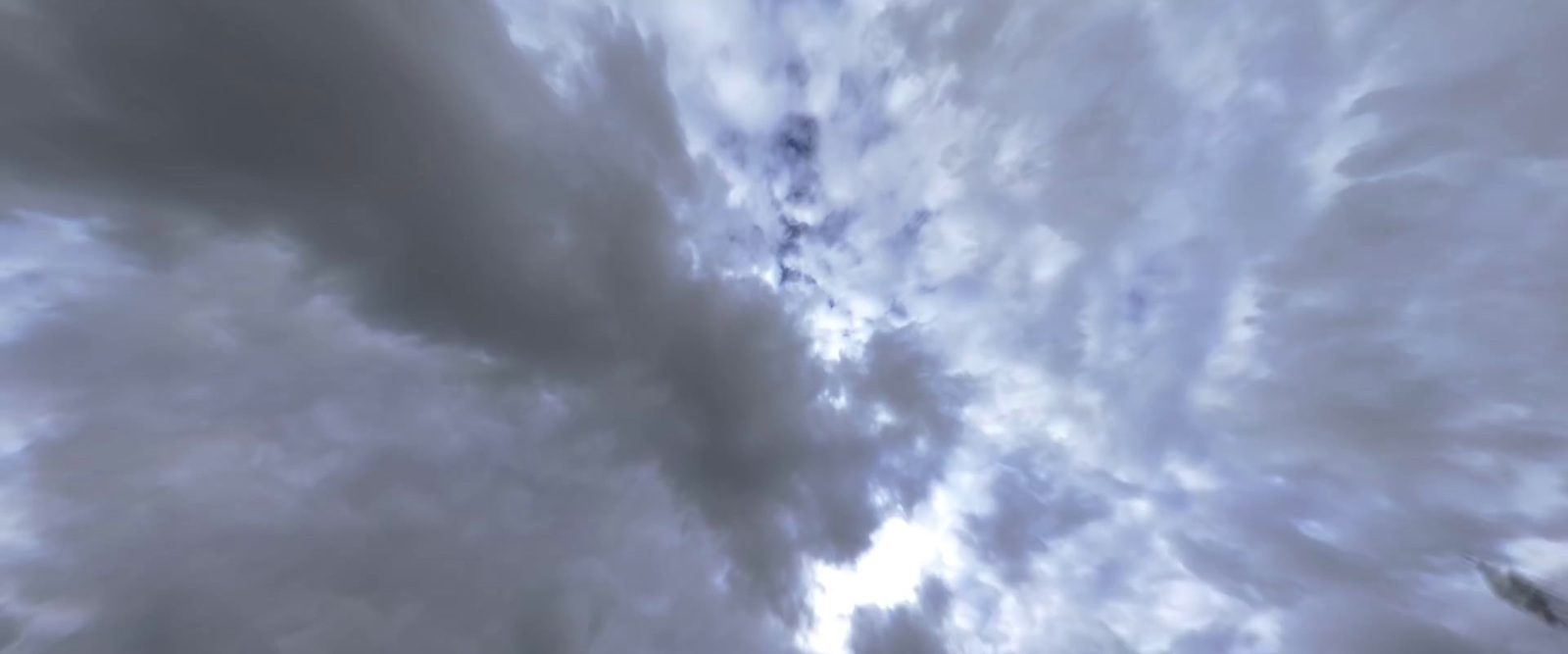 a cloudy sky with a plane flying in the distance