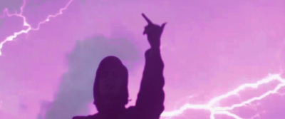 a silhouette of a person holding a cell phone up in the air