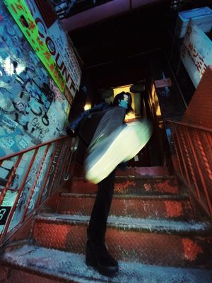 a man carrying a surfboard down a flight of stairs