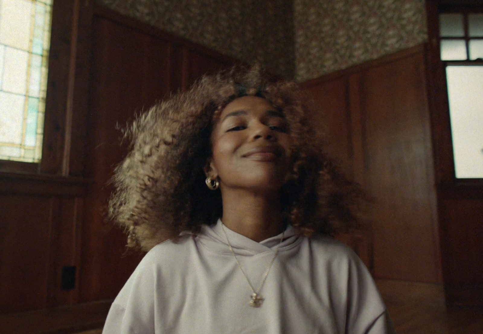 a woman with curly hair standing in a room