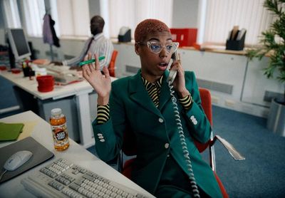 a woman in a green suit talking on a phone