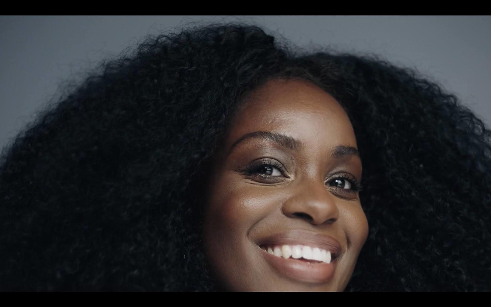 a close up of a smiling woman with long black hair