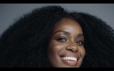 a close up of a smiling woman with long black hair