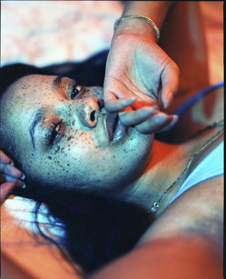 a woman with freckles on her face laying on a bed