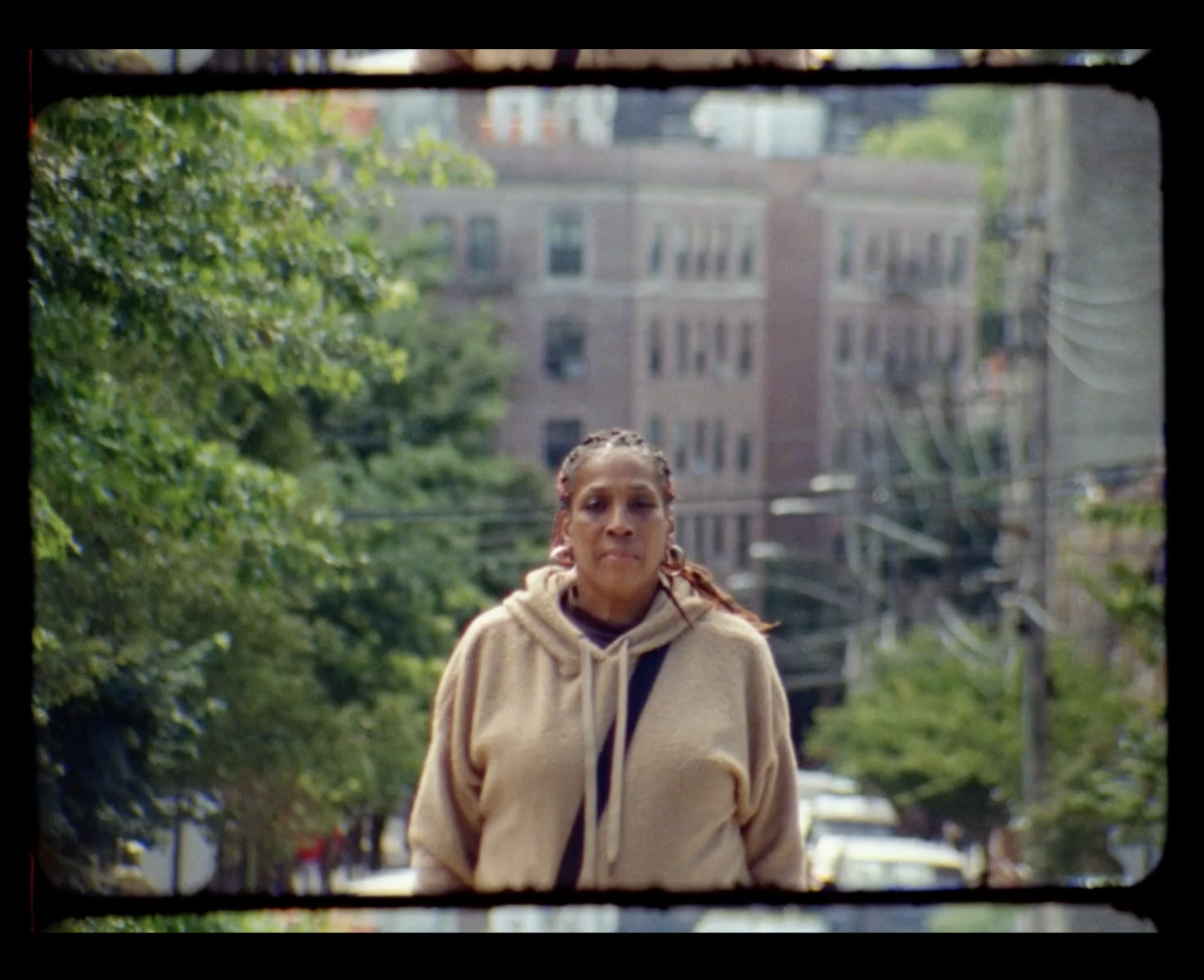 a woman walking down a street next to tall buildings