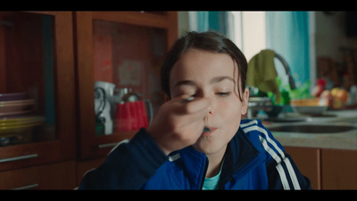 a woman is eating something in a kitchen