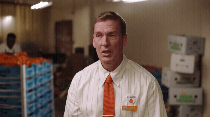 a man in a white shirt and orange tie