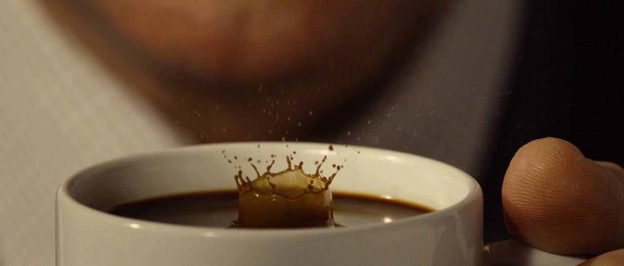 a cup of coffee with a liquid splashing out of it