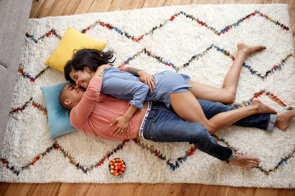 a man and a woman laying on a rug