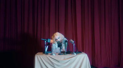 a table topped with microphones next to a red curtain