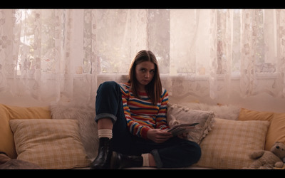 a woman sitting on top of a couch next to a window