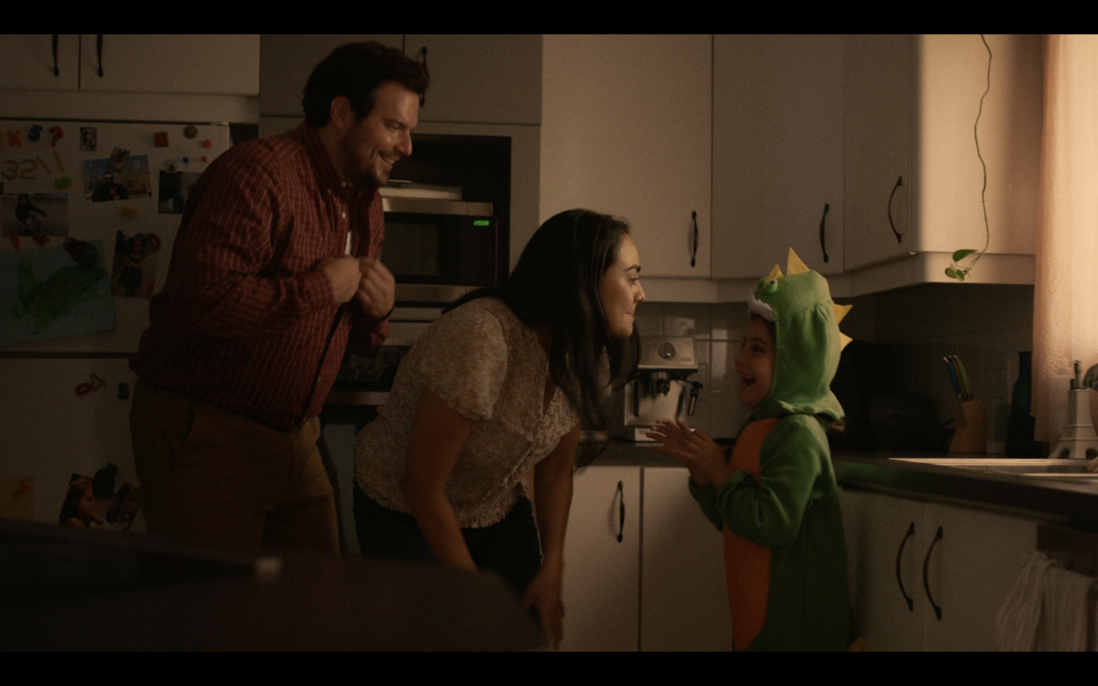 a man standing next to a little girl in a kitchen