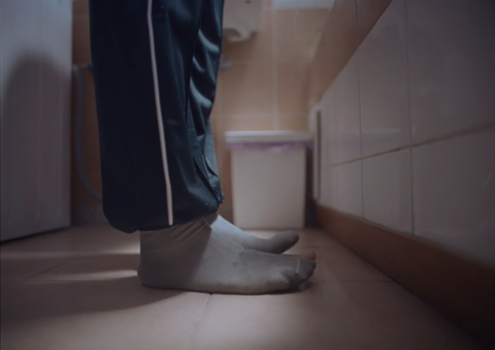 a person standing on a bathroom floor next to a toilet