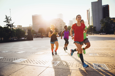 a group of women running on a city street