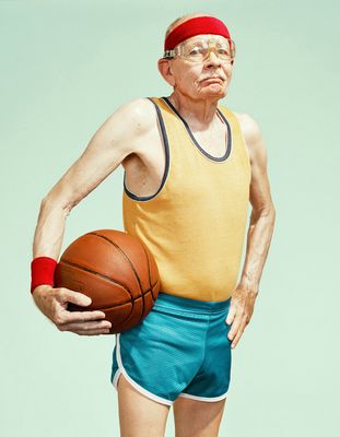 an old man holding a basketball in his hands