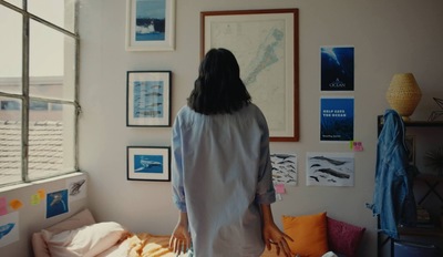 a woman standing in a bedroom looking out a window