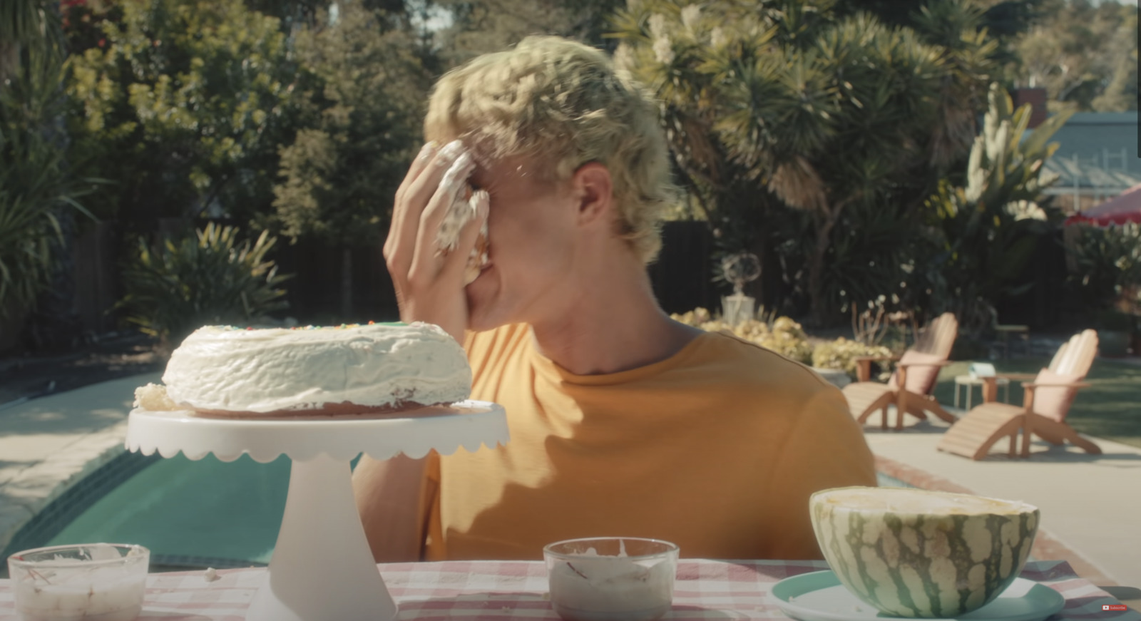 a man sitting at a table with a cake in front of him