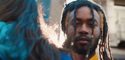 a man with dreadlocks standing next to a woman