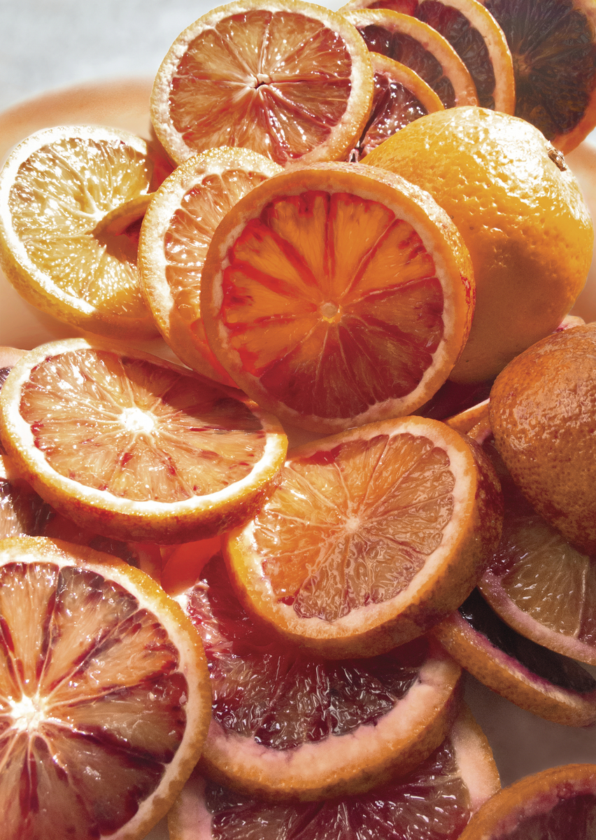 a pile of sliced oranges sitting on top of a white plate