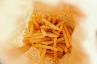 a pile of french fries sitting inside of a bag