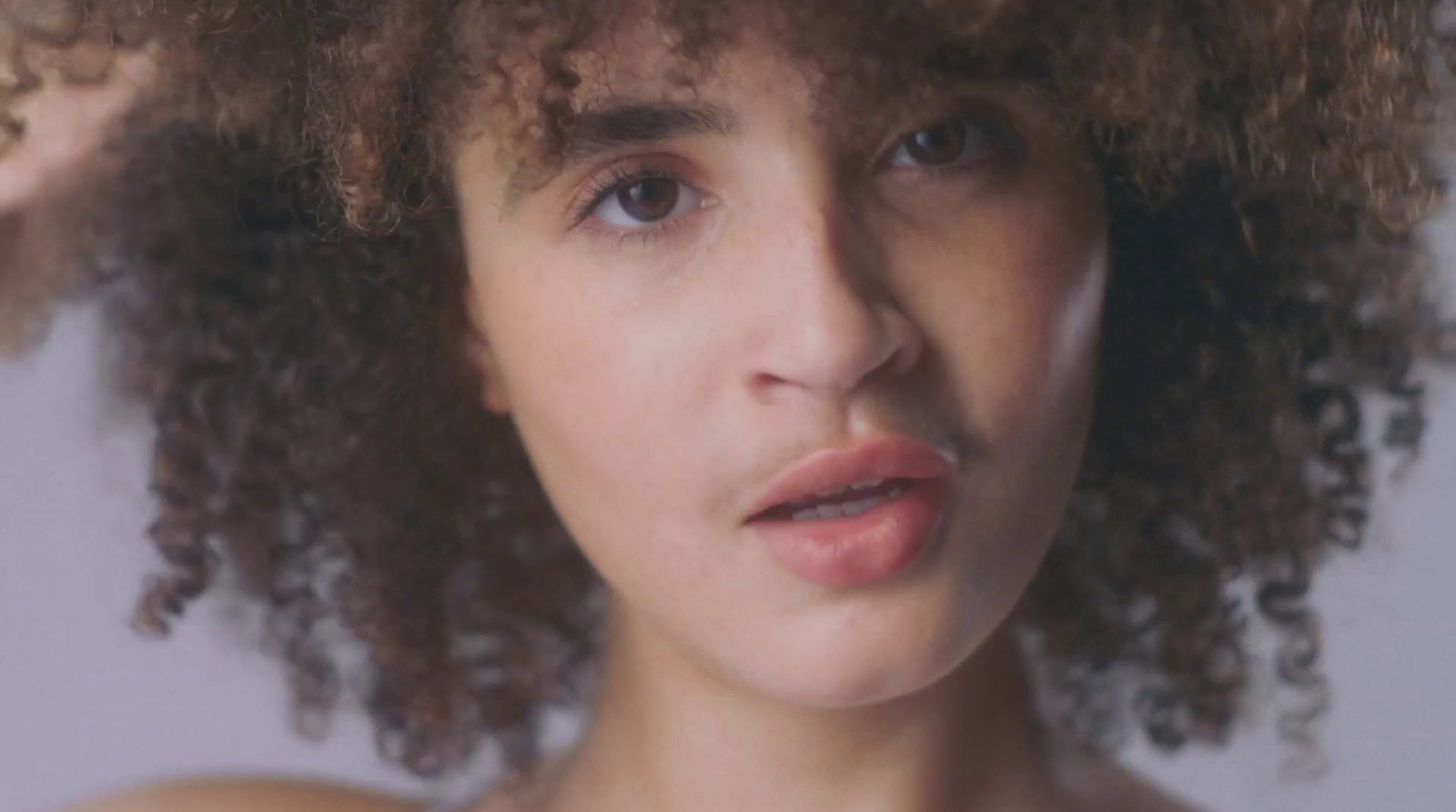 a close up of a woman with curly hair