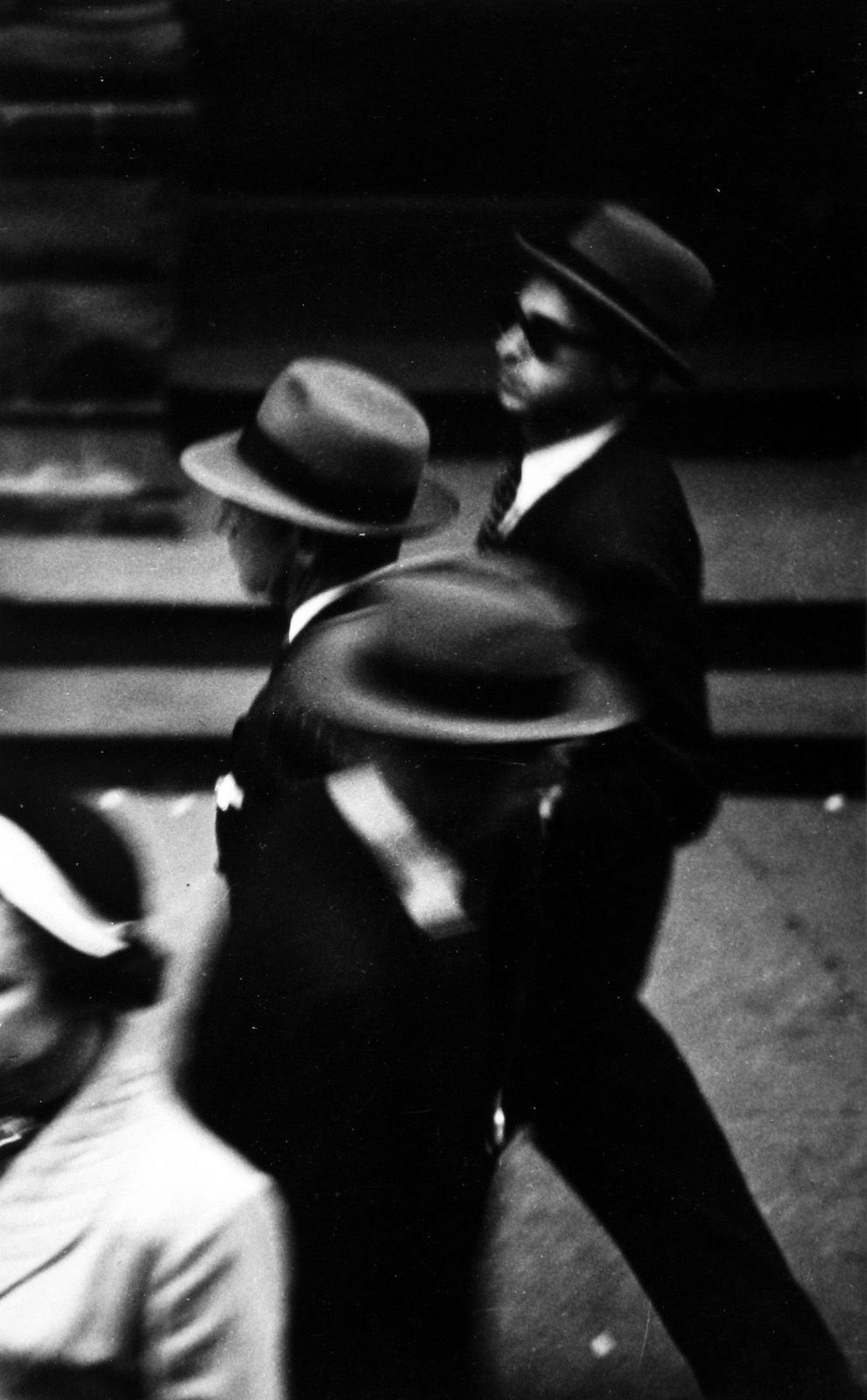 a black and white photo of a man in a suit and hat