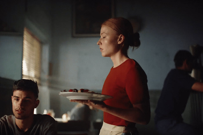 a woman holding a plate of food while standing next to a man