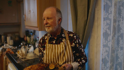 a man holding a turkey in a kitchen