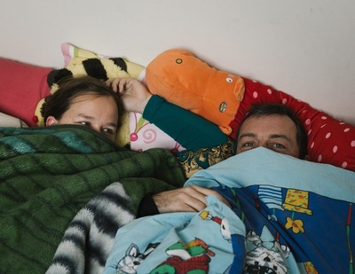 a man and a woman laying in bed under blankets