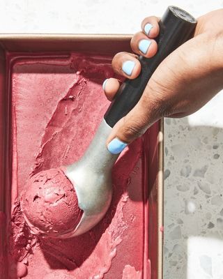 a person is holding a spoon over a scoop of ice cream