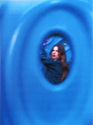 a woman is seen through a blue tube