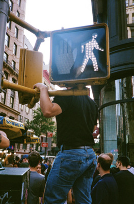 a man holding up a pedestrian crossing sign