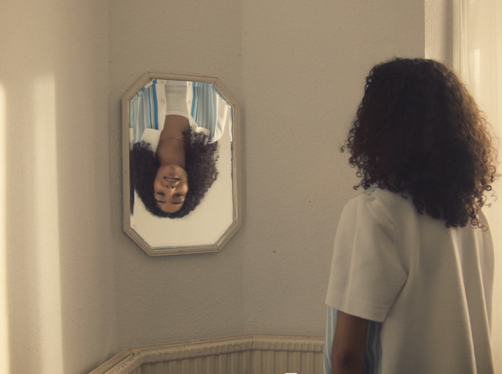 a woman looking at her reflection in a mirror