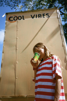 a girl in a striped shirt drinking from a cup