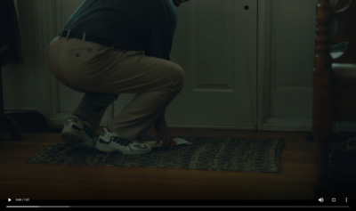 a man kneeling on a rug in front of a door