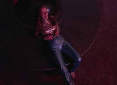 a woman laying on the ground in front of a round object