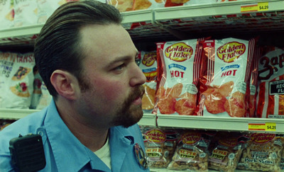 a man in a store looking at a bag of chips