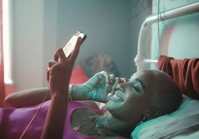 a woman laying in bed while holding a cell phone