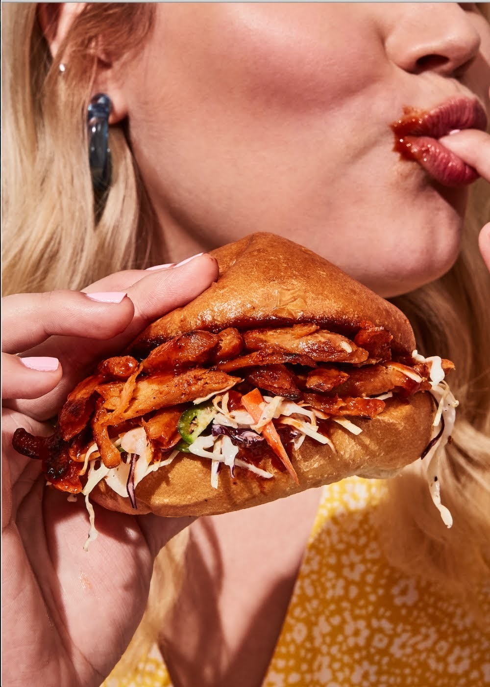 a woman eating a sandwich with a bite taken out of it