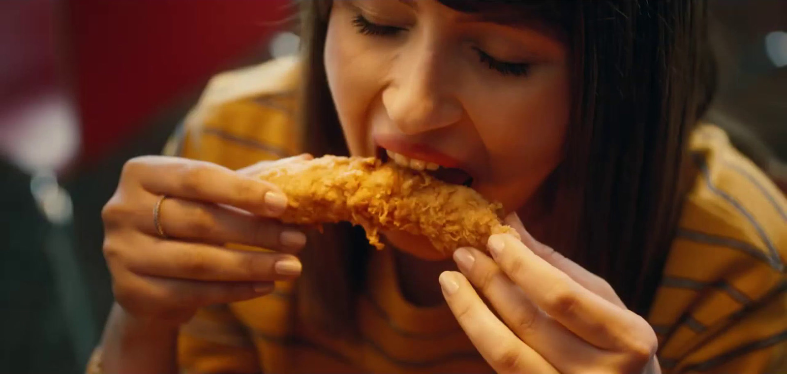 a woman eating a piece of fried food