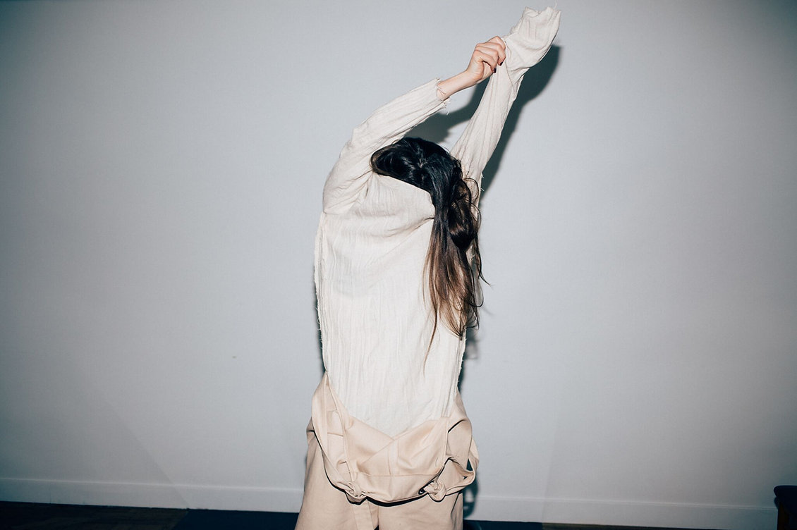 a woman in a white shirt is doing a handstand