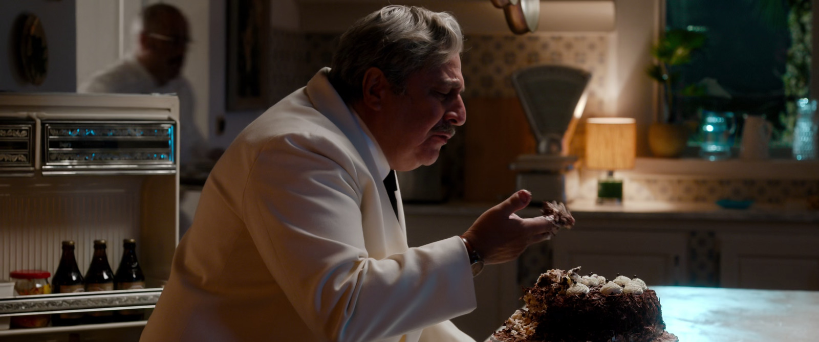 a man standing in front of a cake