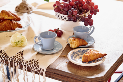 a table topped with plates of food and cups of coffee