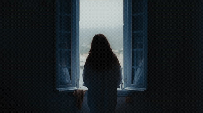 a woman standing in front of a window